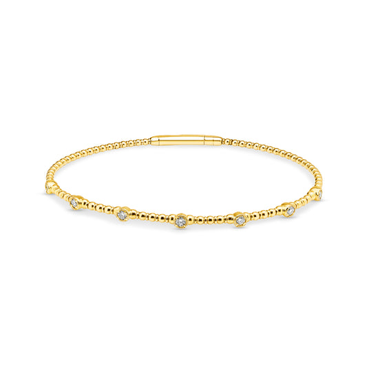 14ct yellow gold granule style bangle featuring 7 diamonds set into individual round stations weighing a total of 0.24ct. Flexi-style bangle with an easy close clasp